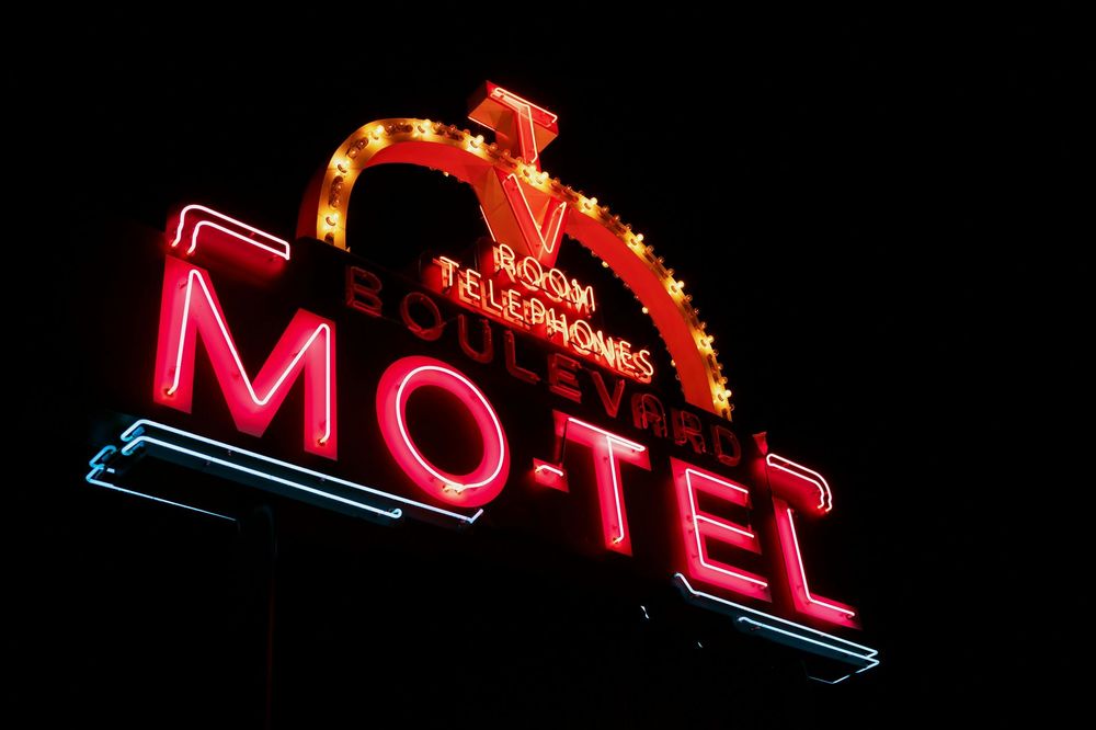Neon sign for a motel, red letters spell 