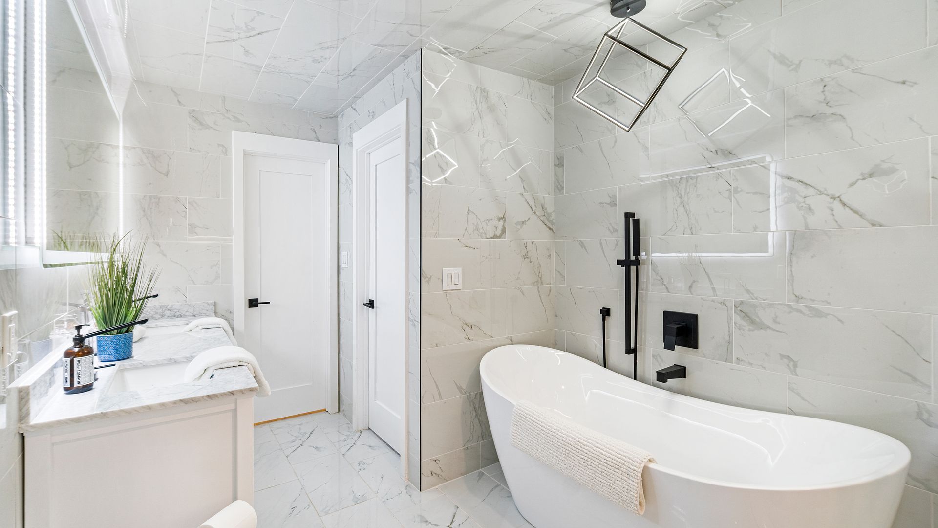 Modern white bathroom with a soaking tub and marble tile.