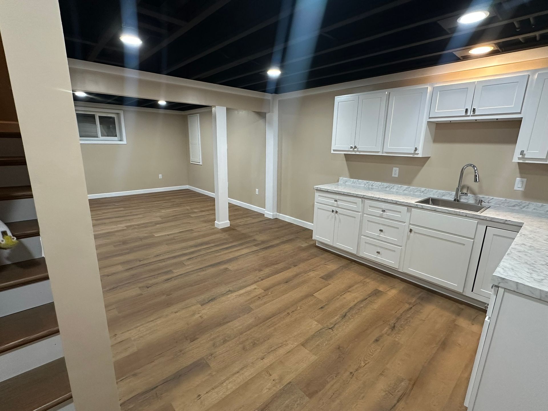 Basement with unfinished walls, concrete floor, storage, and a support beam.