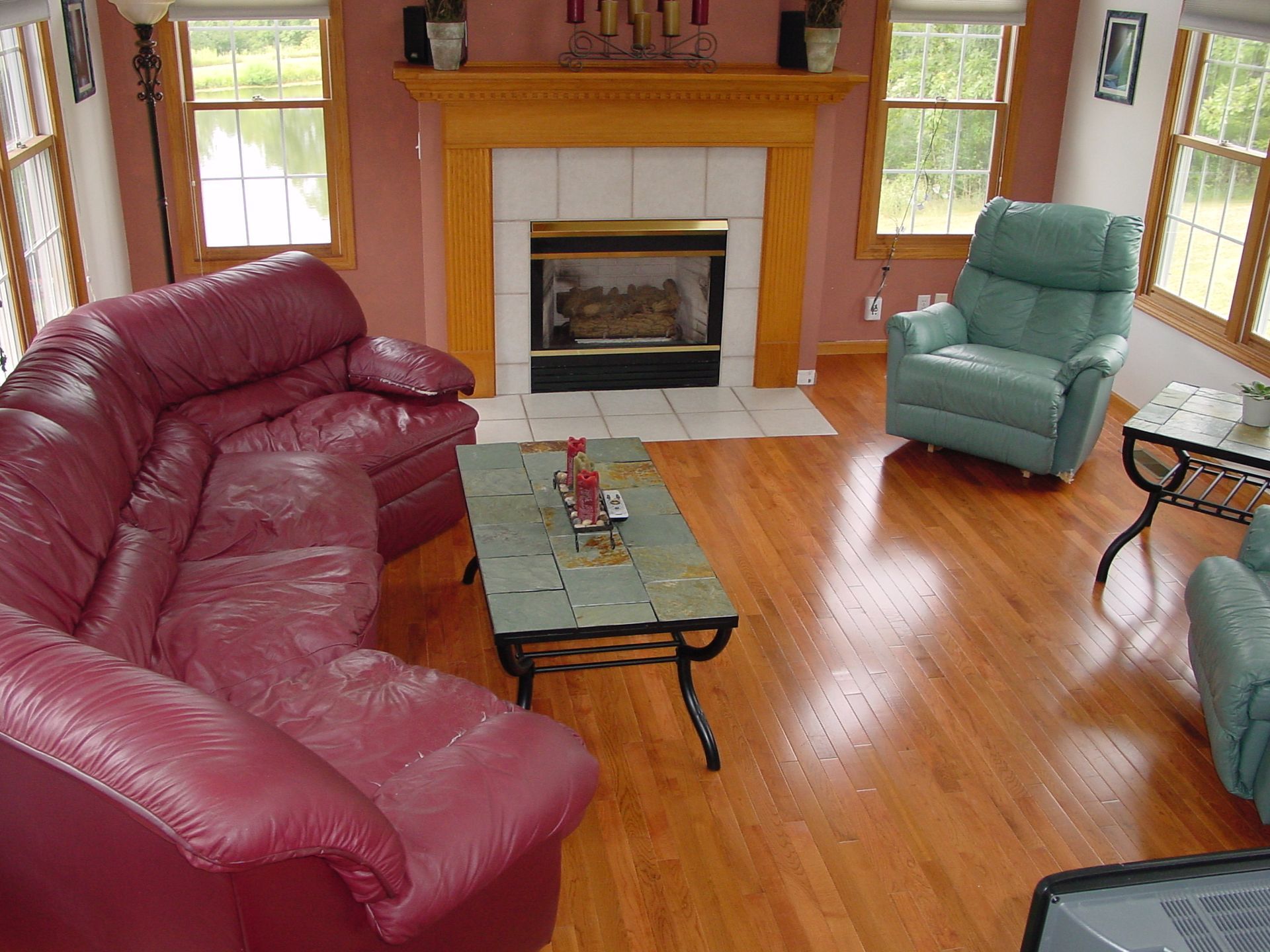 Bathroom with a white sliding door, toilet, sink, mirror, and stainless steel trash can; light blue walls, wood-look tile floor.