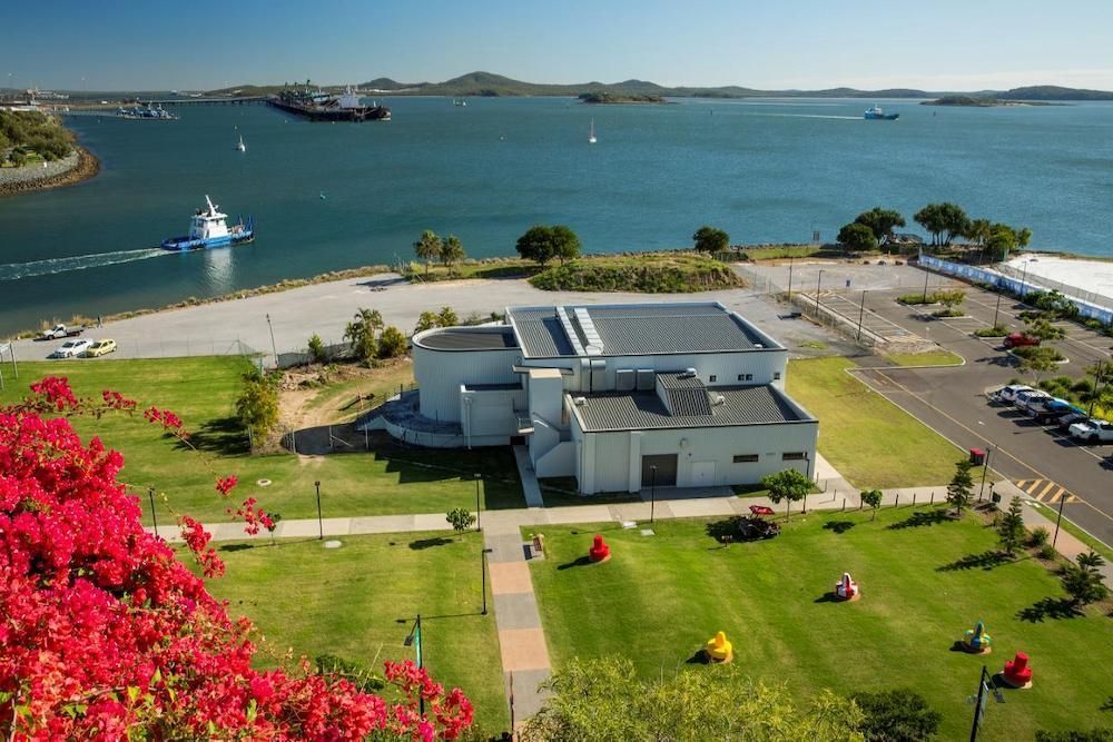 An Aerial View of a Building Next to a Body of Water — Median Law In Gladstone, QLD