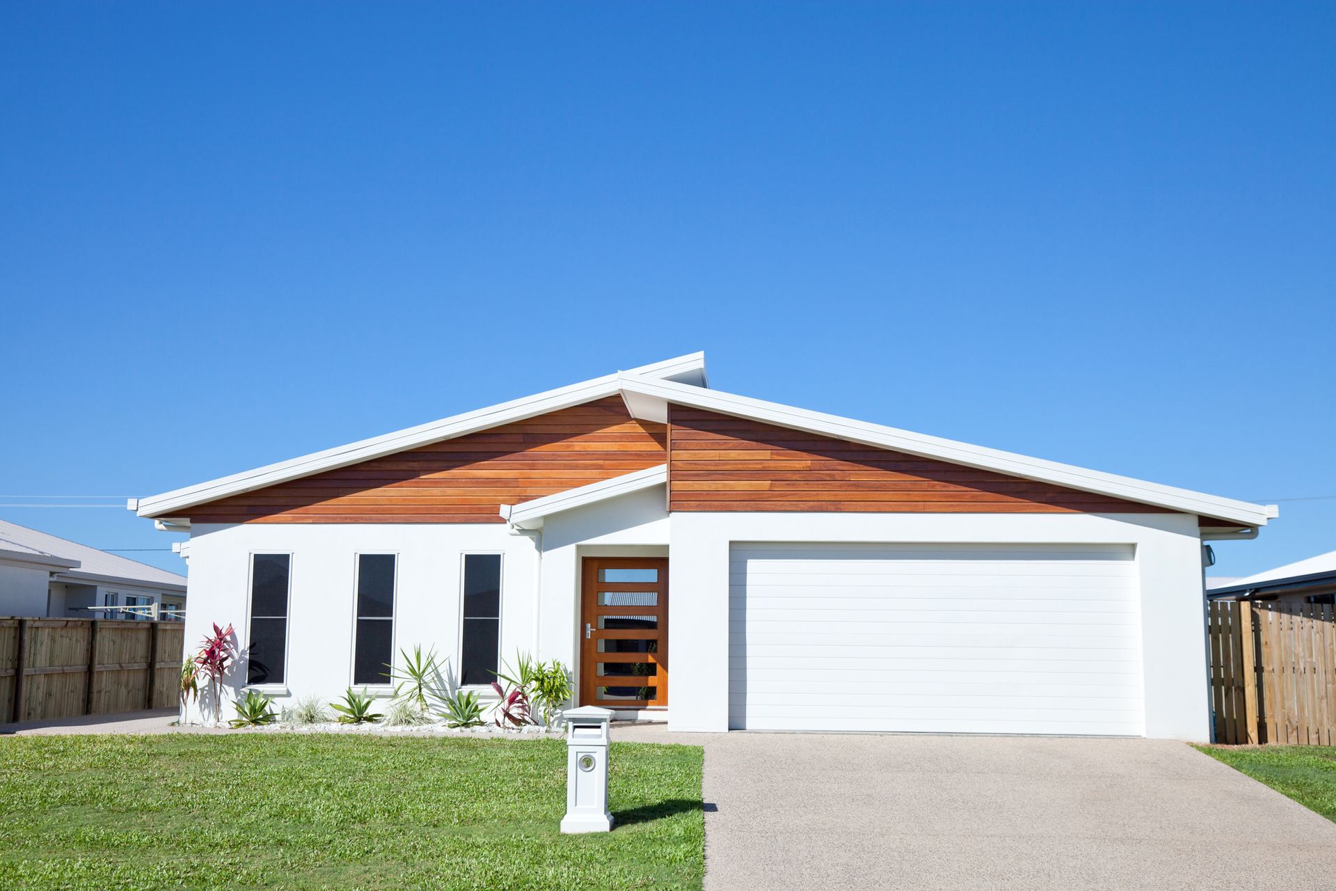 A white house with a wooden roof and a white garage door.