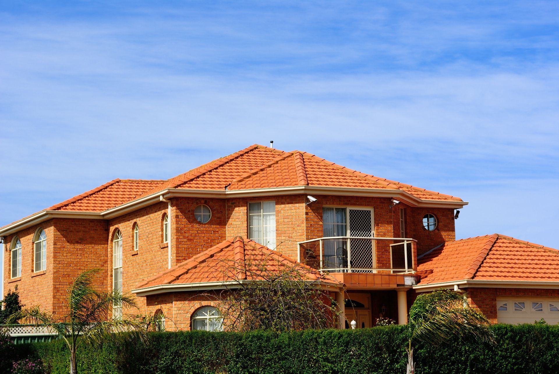 A man is laying shingles on a roof.