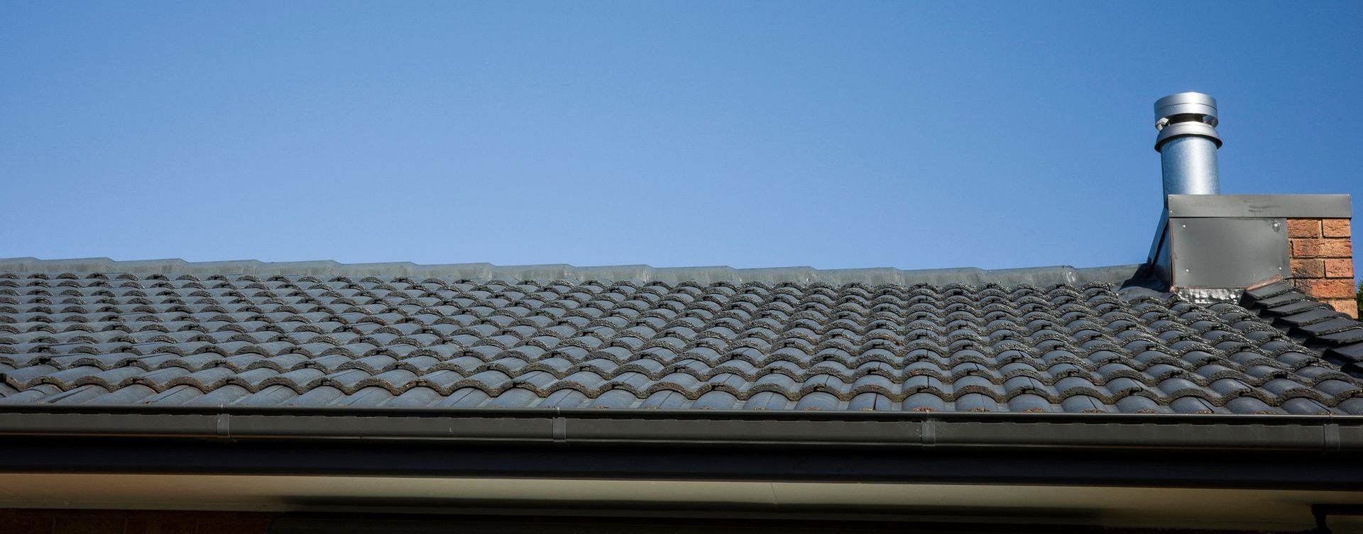 A man is working on a roof with a hammer.