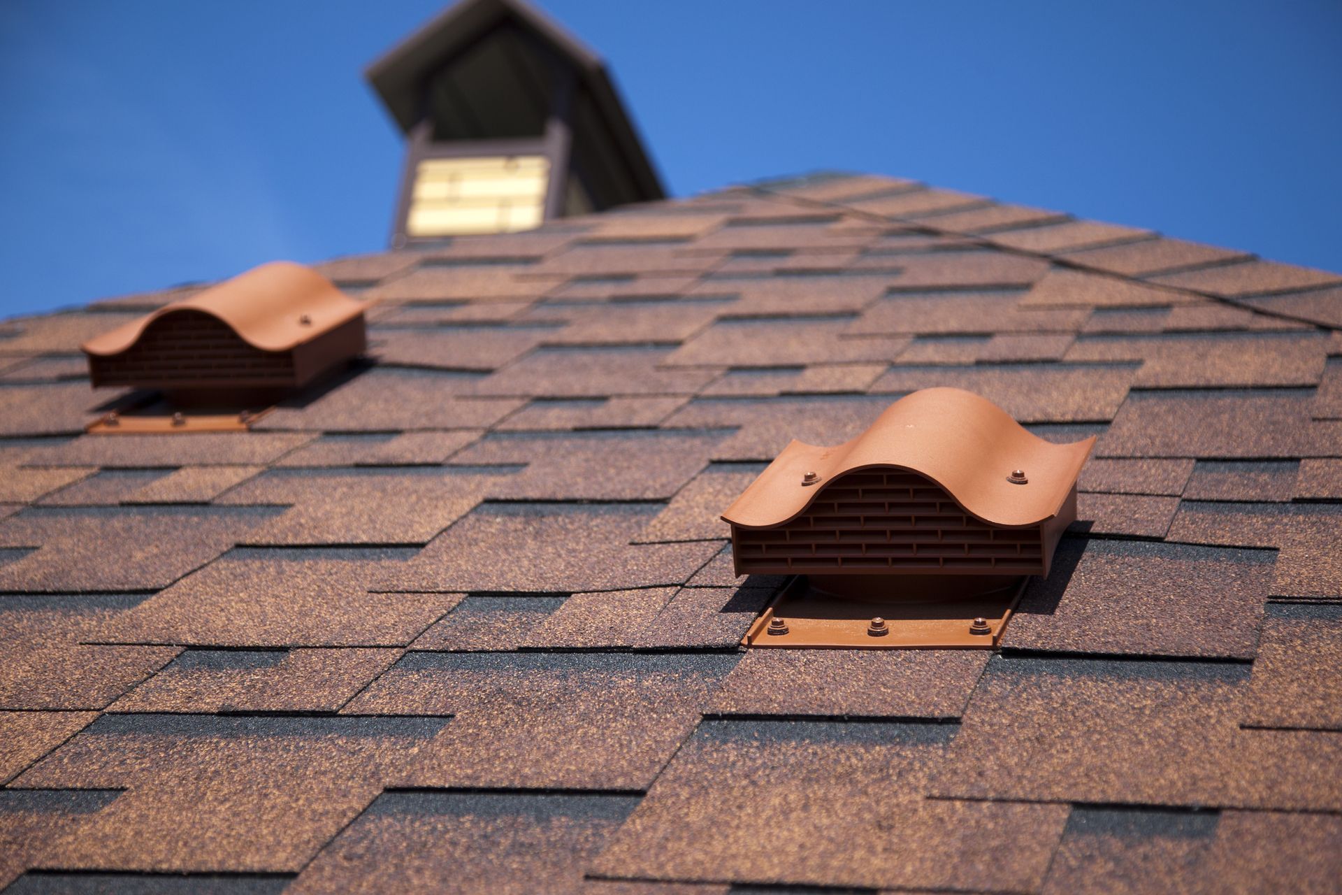 A close up of a roof with two vents on it