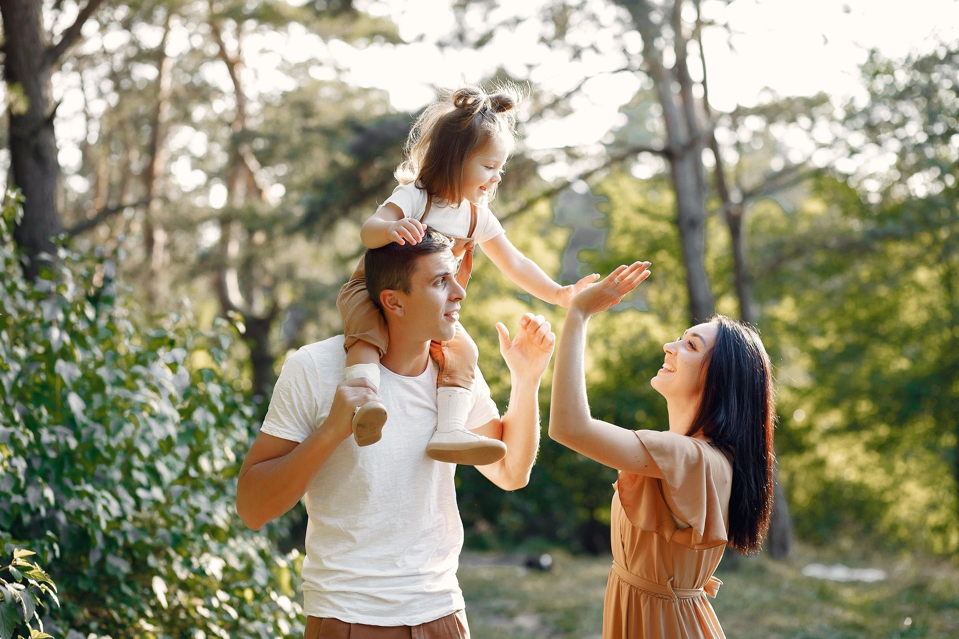 A family is walking through a field holding hands.