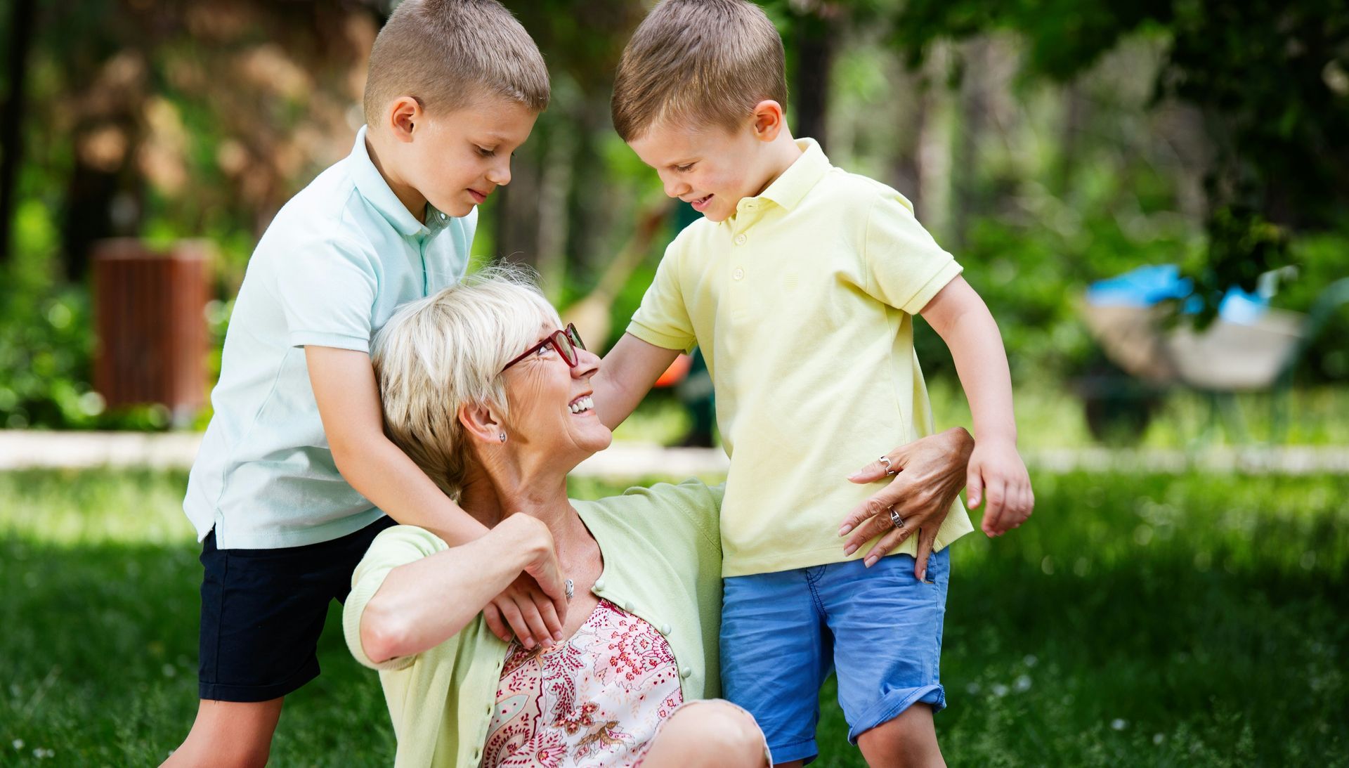 A family is walking through a field holding hands.