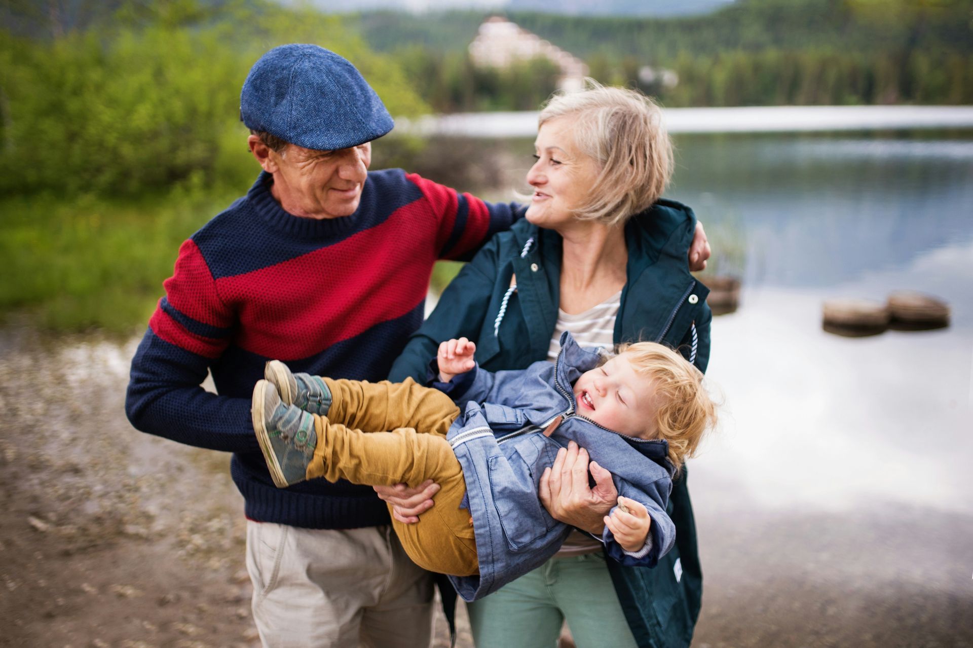 A family is walking through a field holding hands.