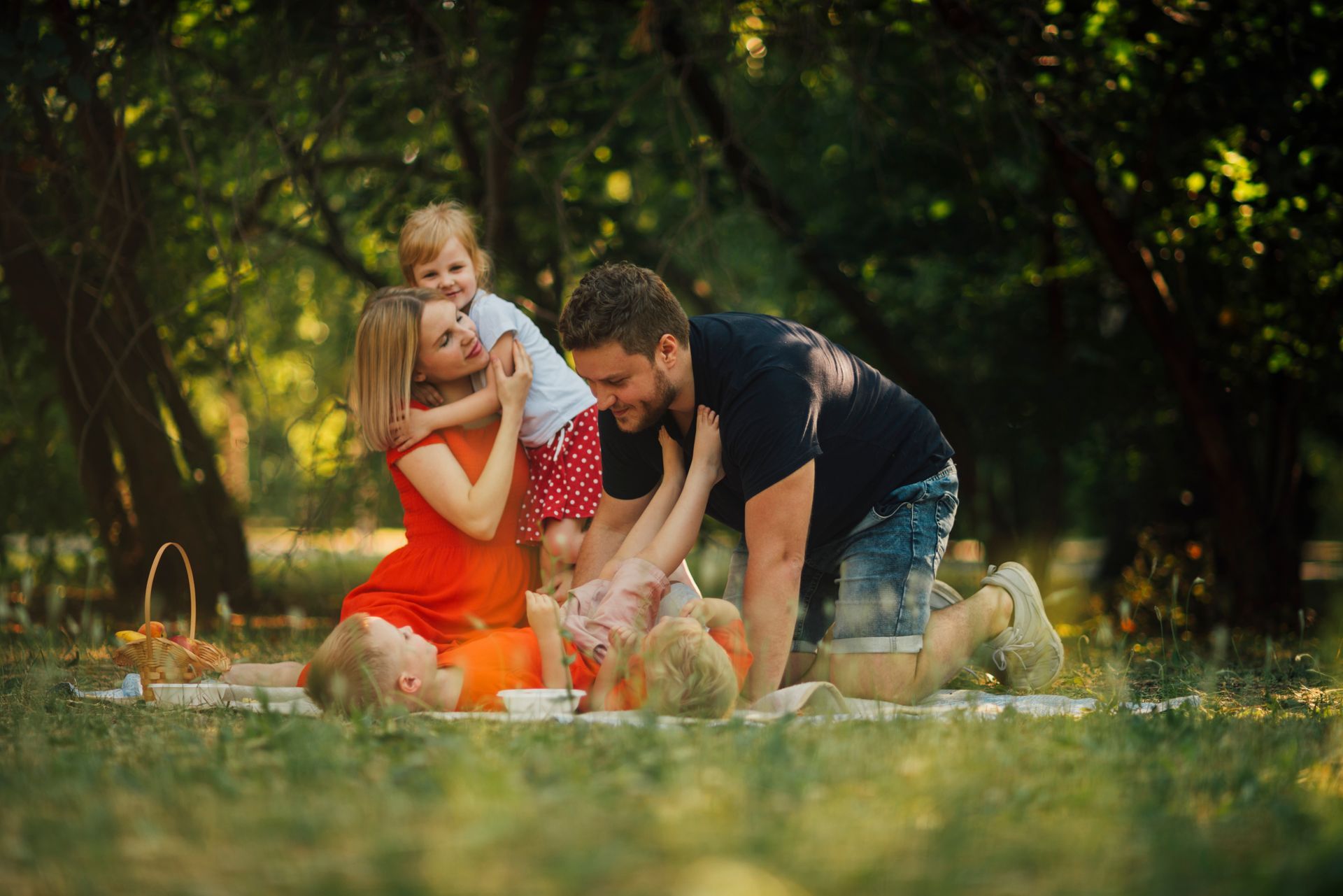 A family is walking through a field holding hands.