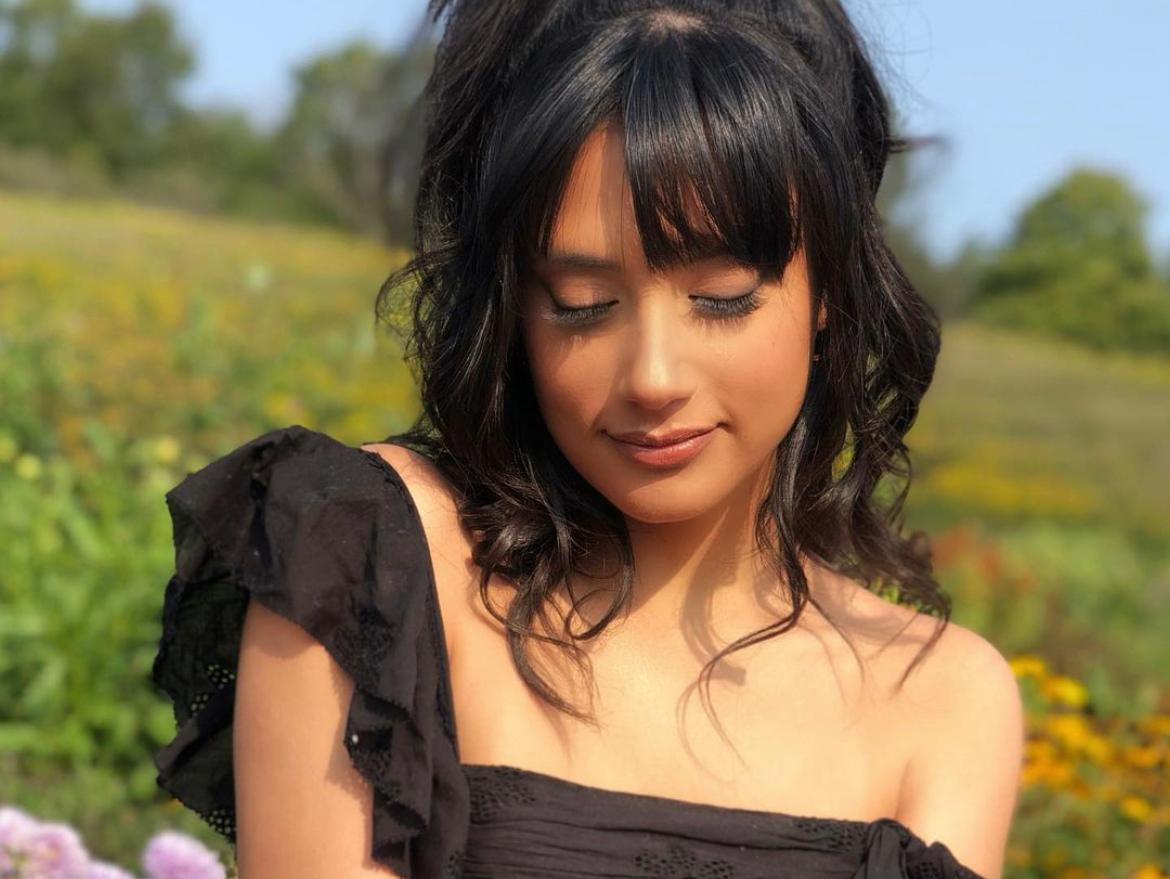 woman wearing professional makeup looking down in sunflower field