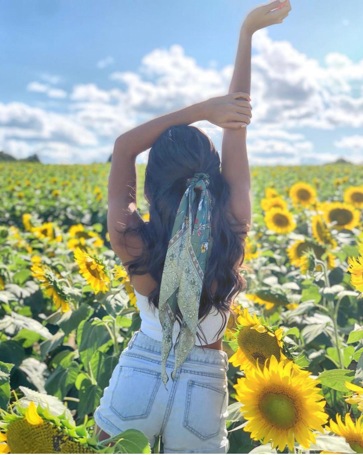woman in sunflower field with hair scarf in hair