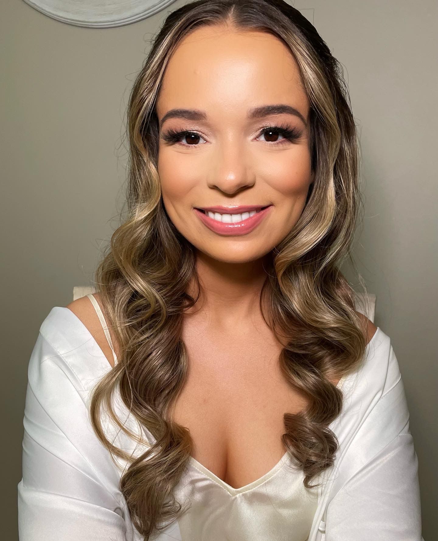 A woman with long hair and a plunging neckline is smiling for the camera.