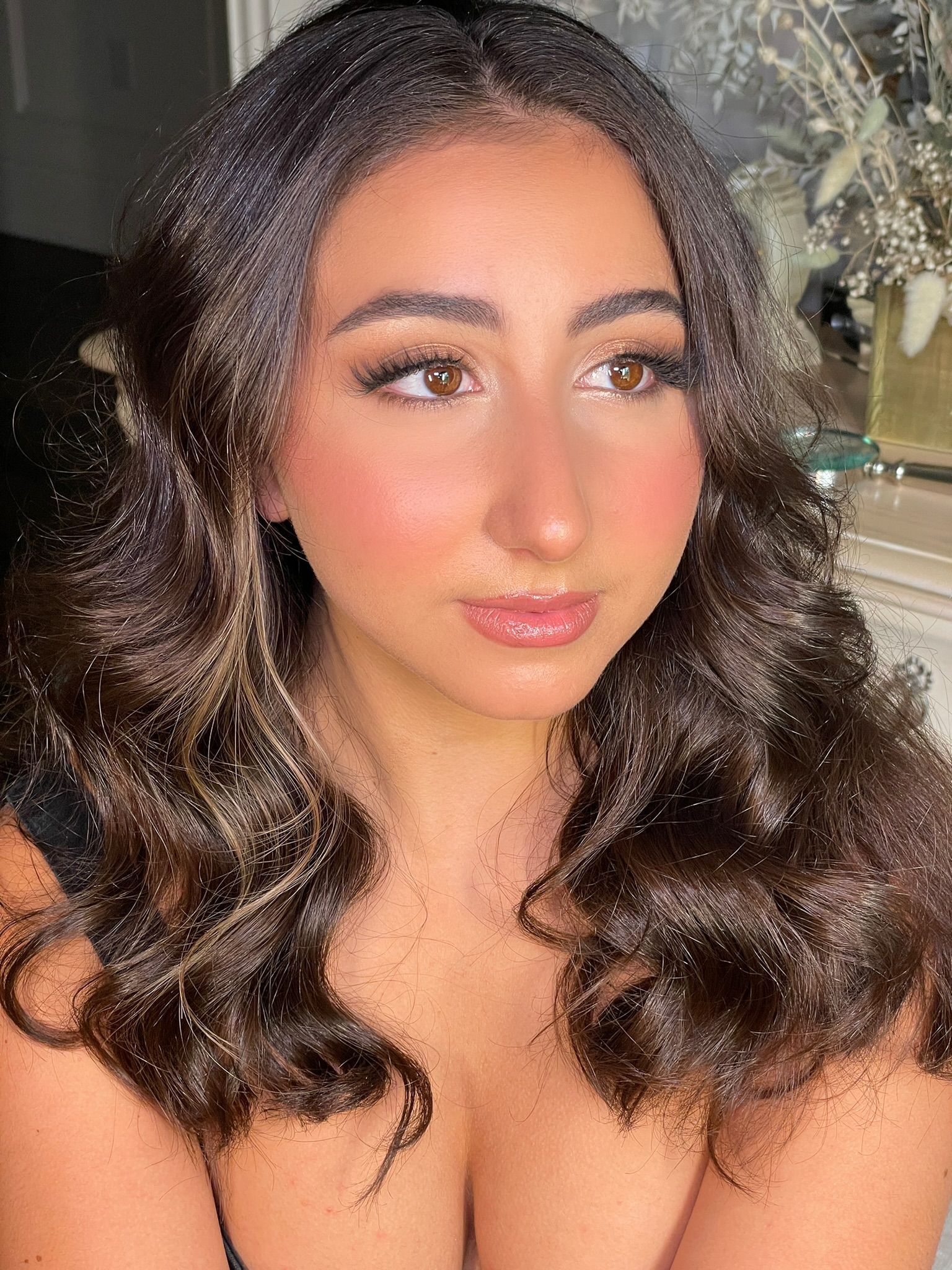 A close up of a woman 's face with long curly hair.