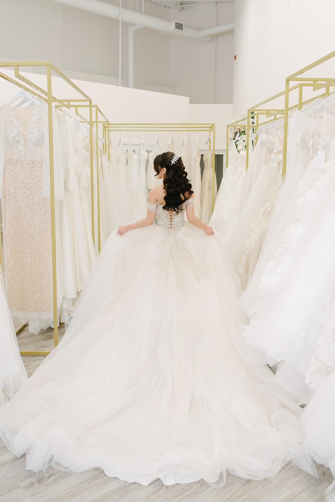 A woman in a wedding dress is sitting in a bridal store.