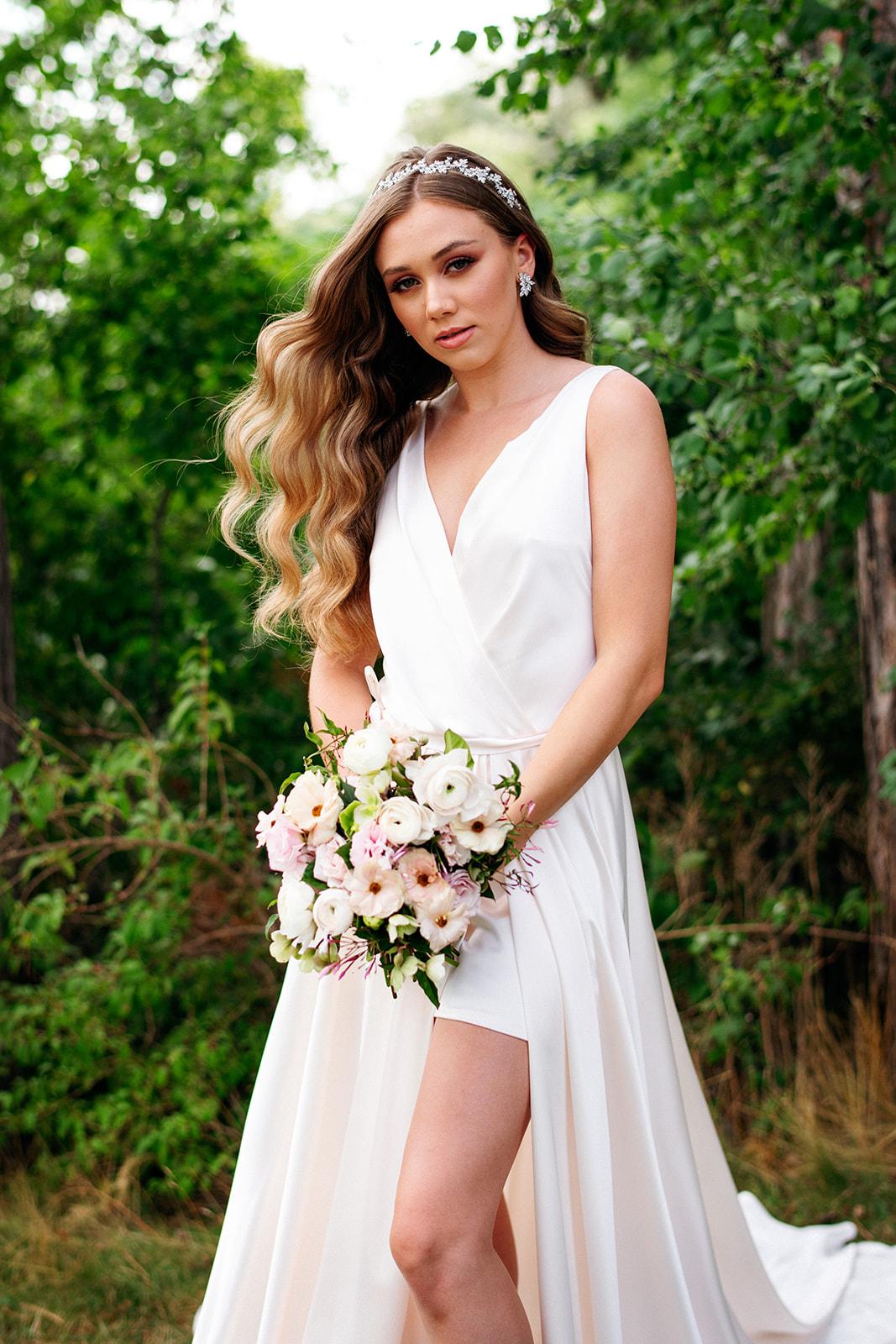 A woman in a white wedding dress is holding a bouquet of flowers.