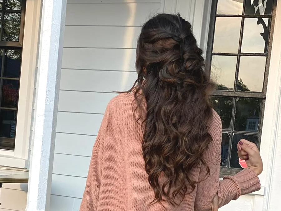 woman with long brown hair with curls and braids wearing black boots