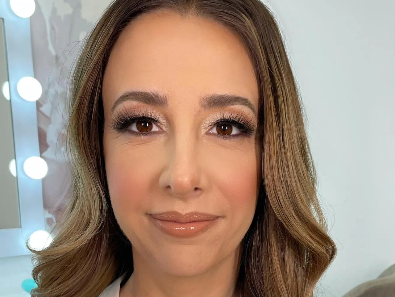 A close up of a woman 's face with makeup on in front of a mirror.