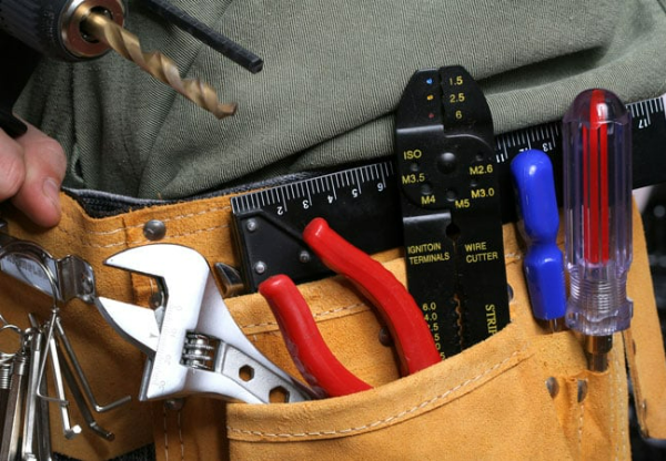 A person wearing a tool belt with tools in it A person wearing a tool belt with tools in it