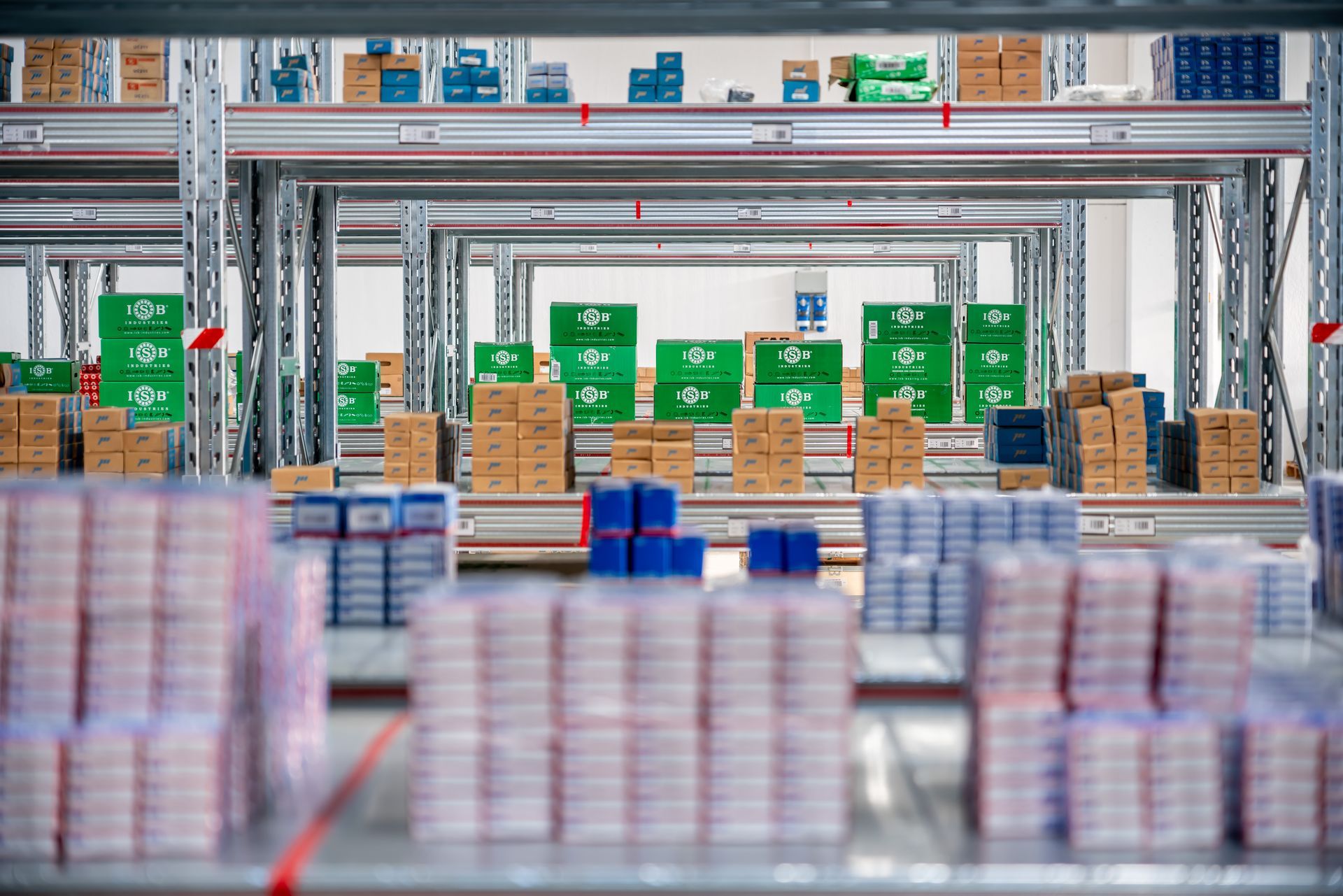 Interno di un magazzino con scaffali pieni di scatole di vari colori.