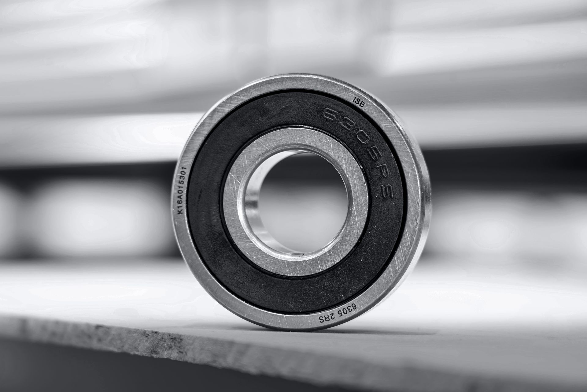 Un cuscinetto a sfere con guarnizione in gomma nera su una superficie di legno.