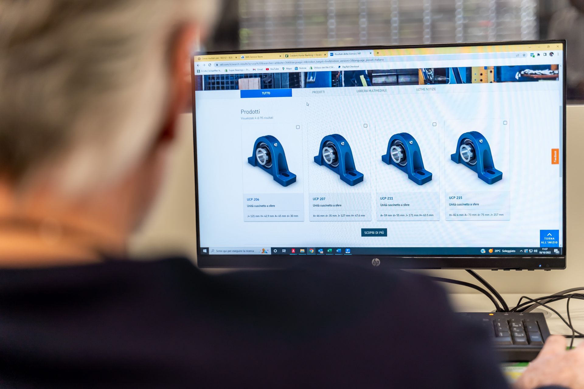 Persona che utilizza il computer per visualizzare e selezionare i cuscinetti online.