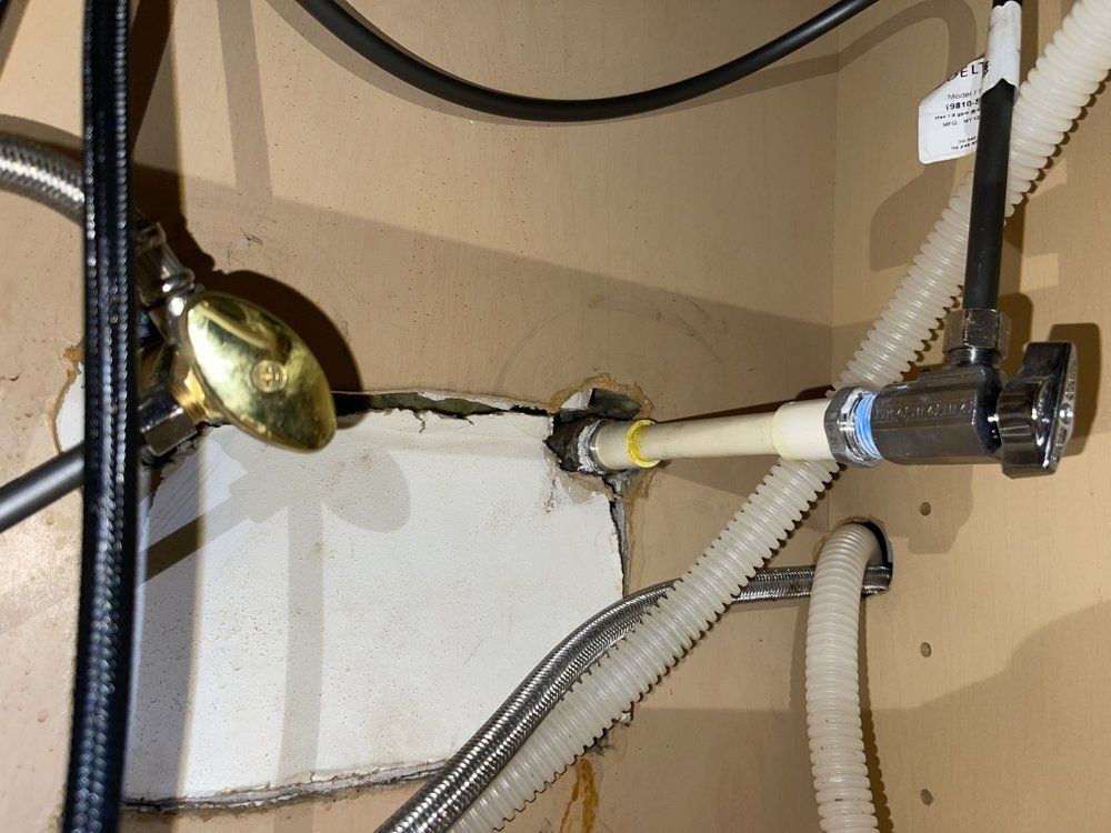 A bathroom sink with a hose and a valve