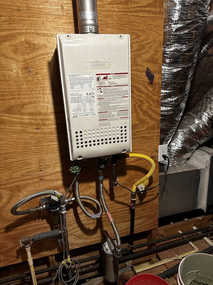 A water heater is sitting on a wooden wall in a room.