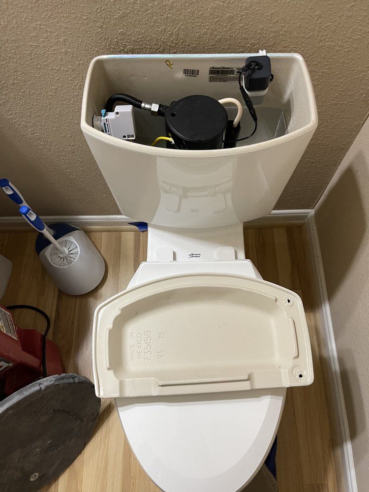 A toilet with the lid open in a bathroom next to a toilet brush.