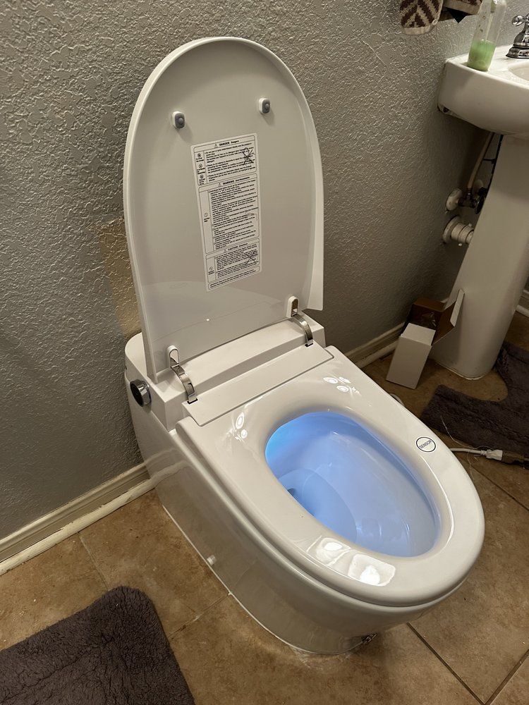 A white toilet is sitting in a bathroom next to a sink.