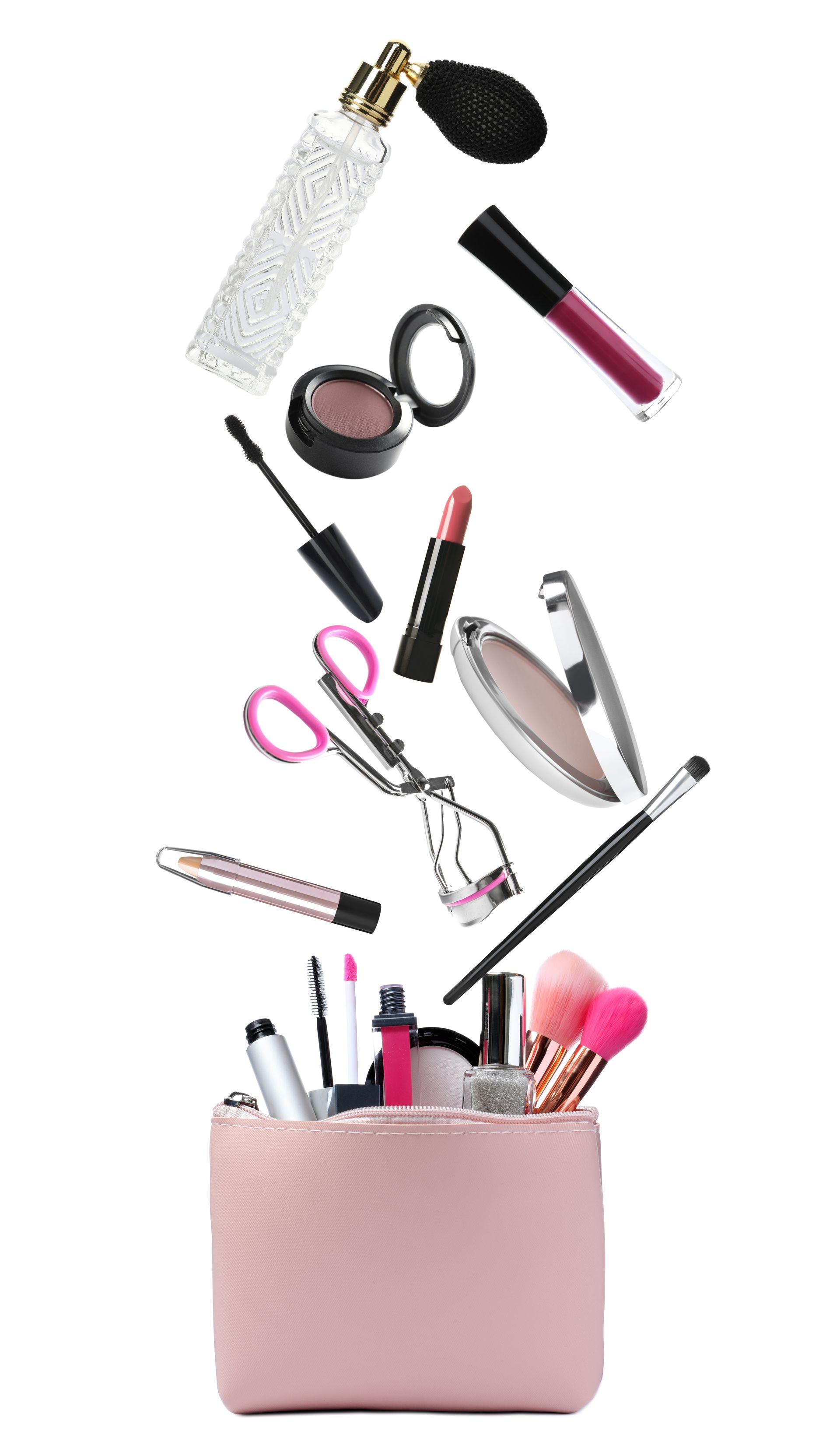 A pink purse filled with cosmetics and brushes falling out of it.