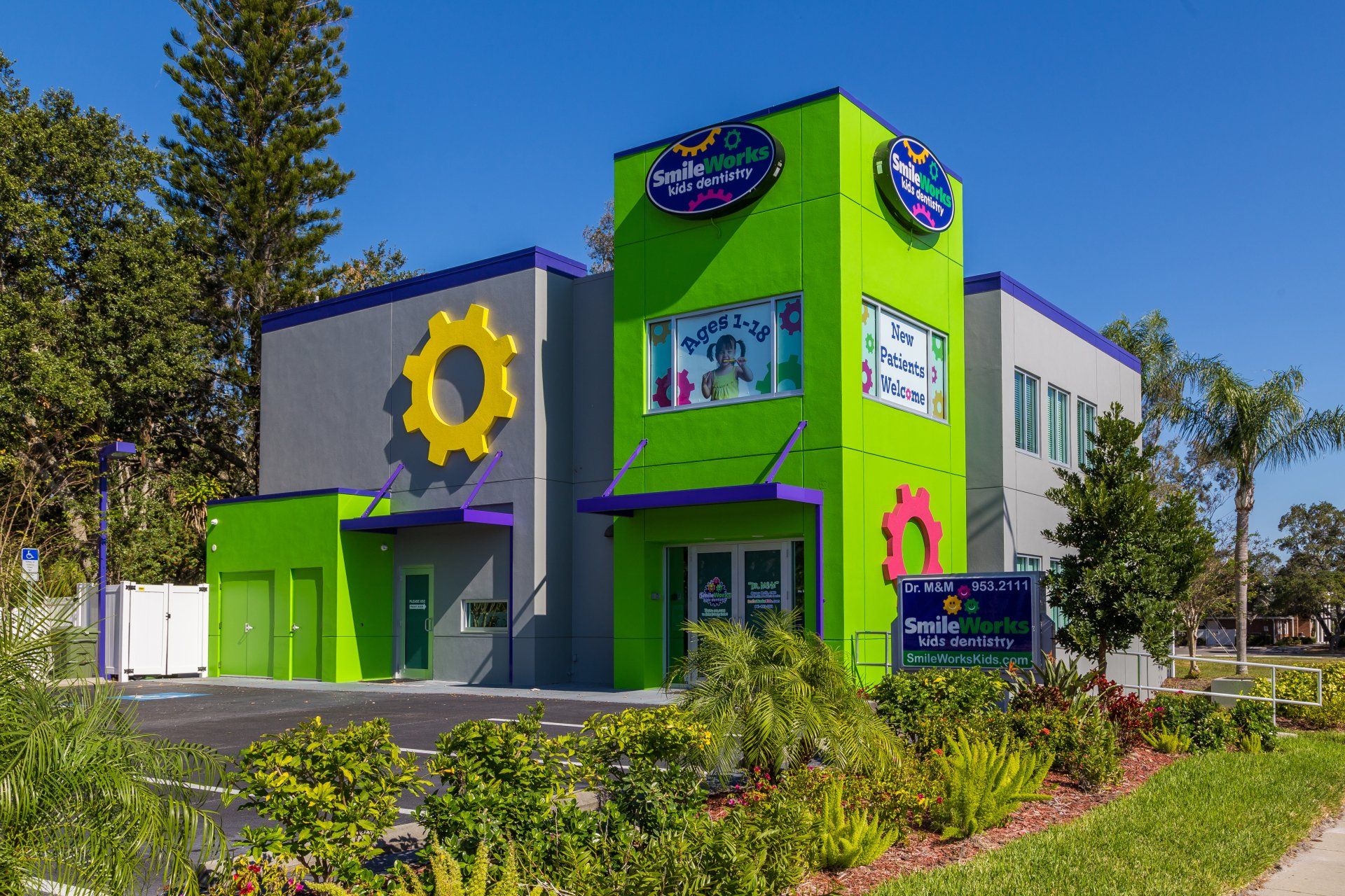 A green and purple building with a yellow gear on the side.