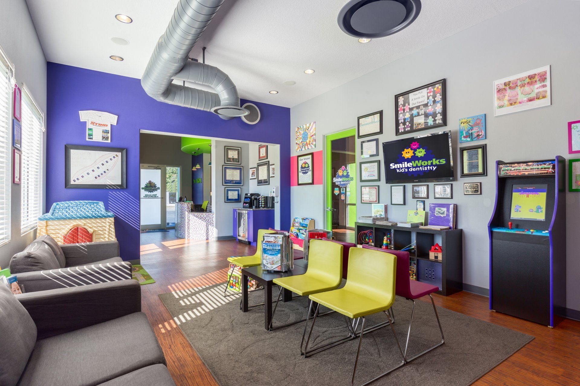 A living room with a couch , chairs , and a video game machine.