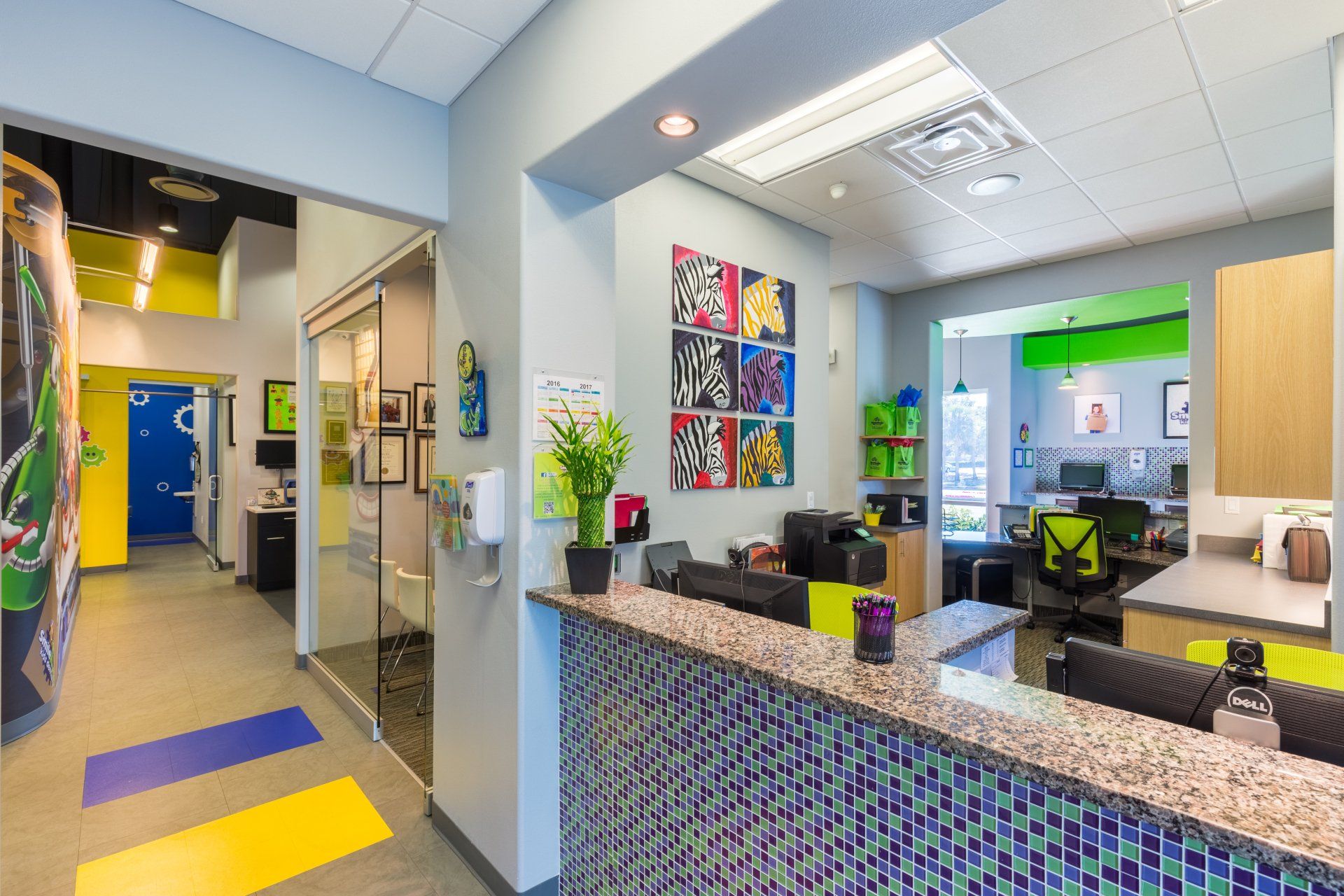 A dental office with a reception desk and a painting on the wall.