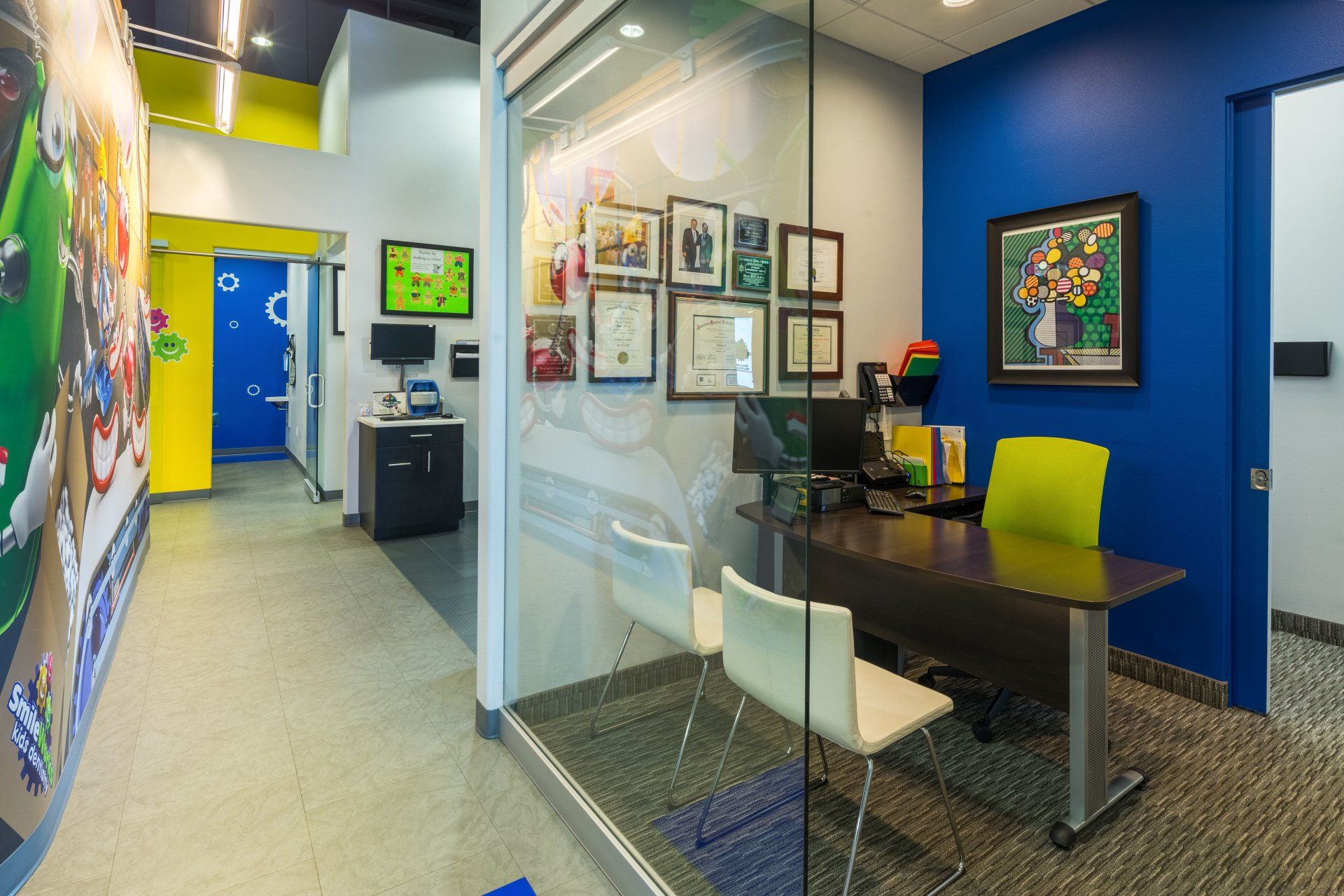 A room with a desk and chairs in it with blue walls.