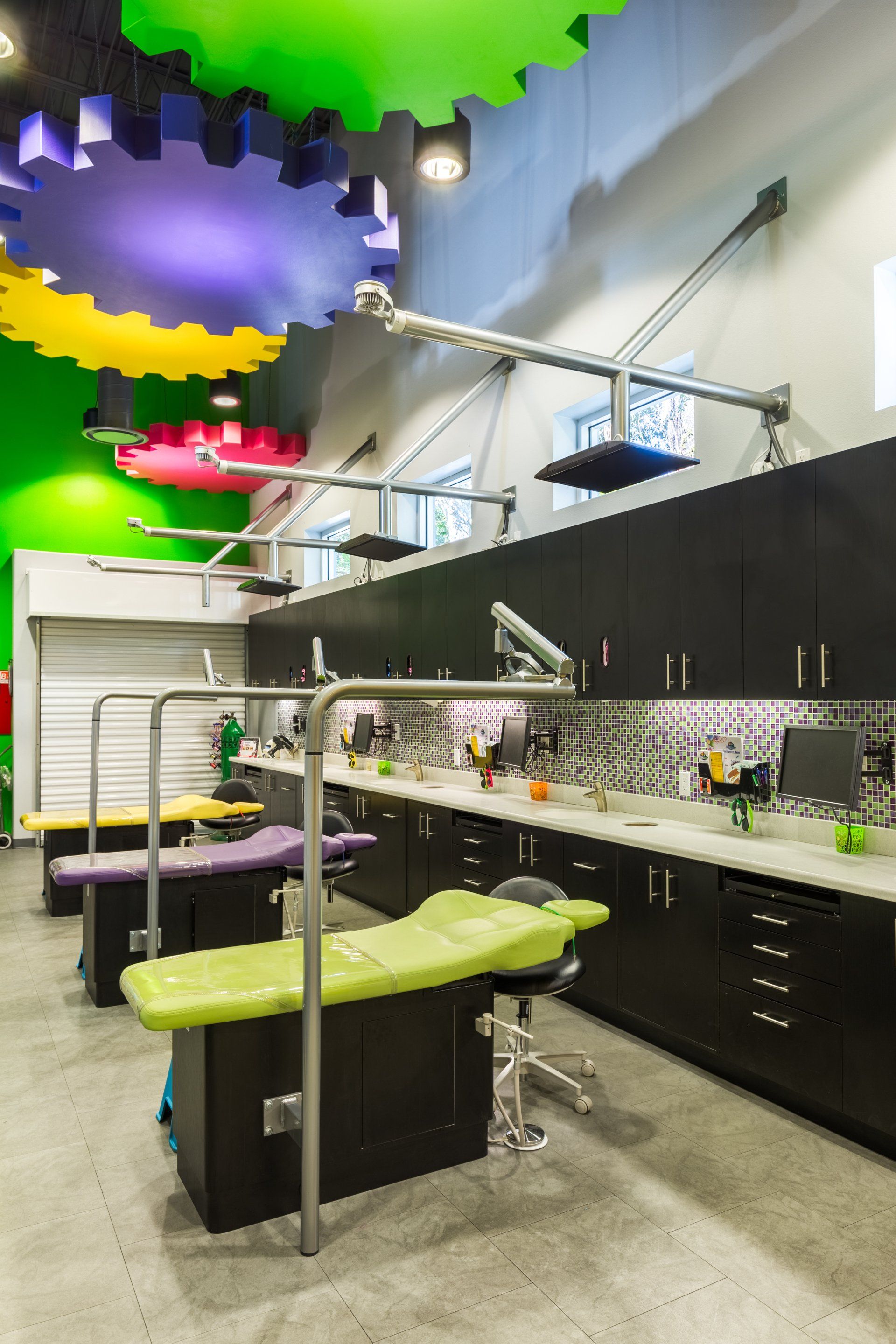 A dental office with a row of dental chairs and a colorful ceiling.