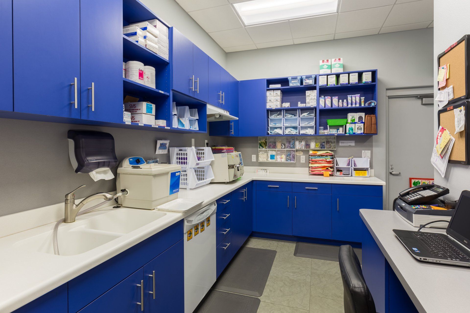 A kitchen with blue cabinets and white counter tops