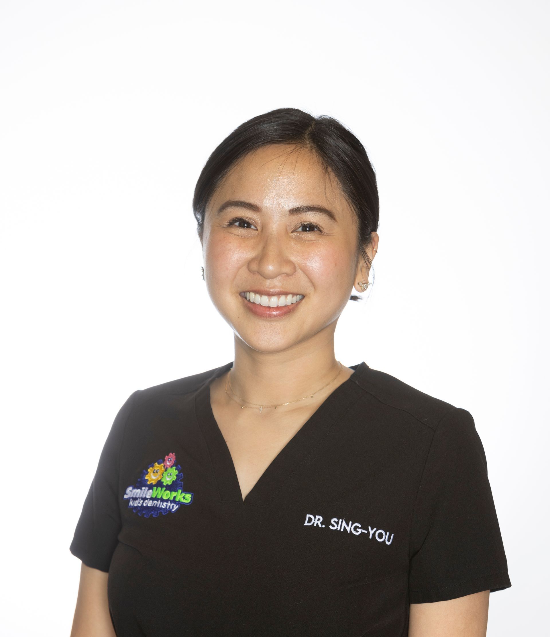 The woman is wearing a black sweater and smiling for the camera.