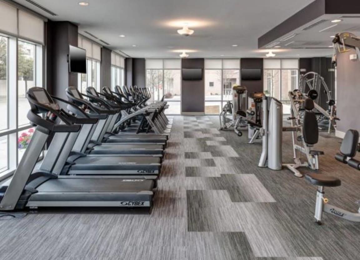 A gym with a lot of treadmills and exercise equipment