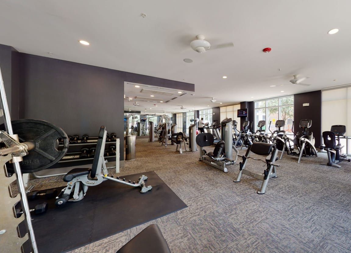 A large gym filled with lots of exercise equipment.