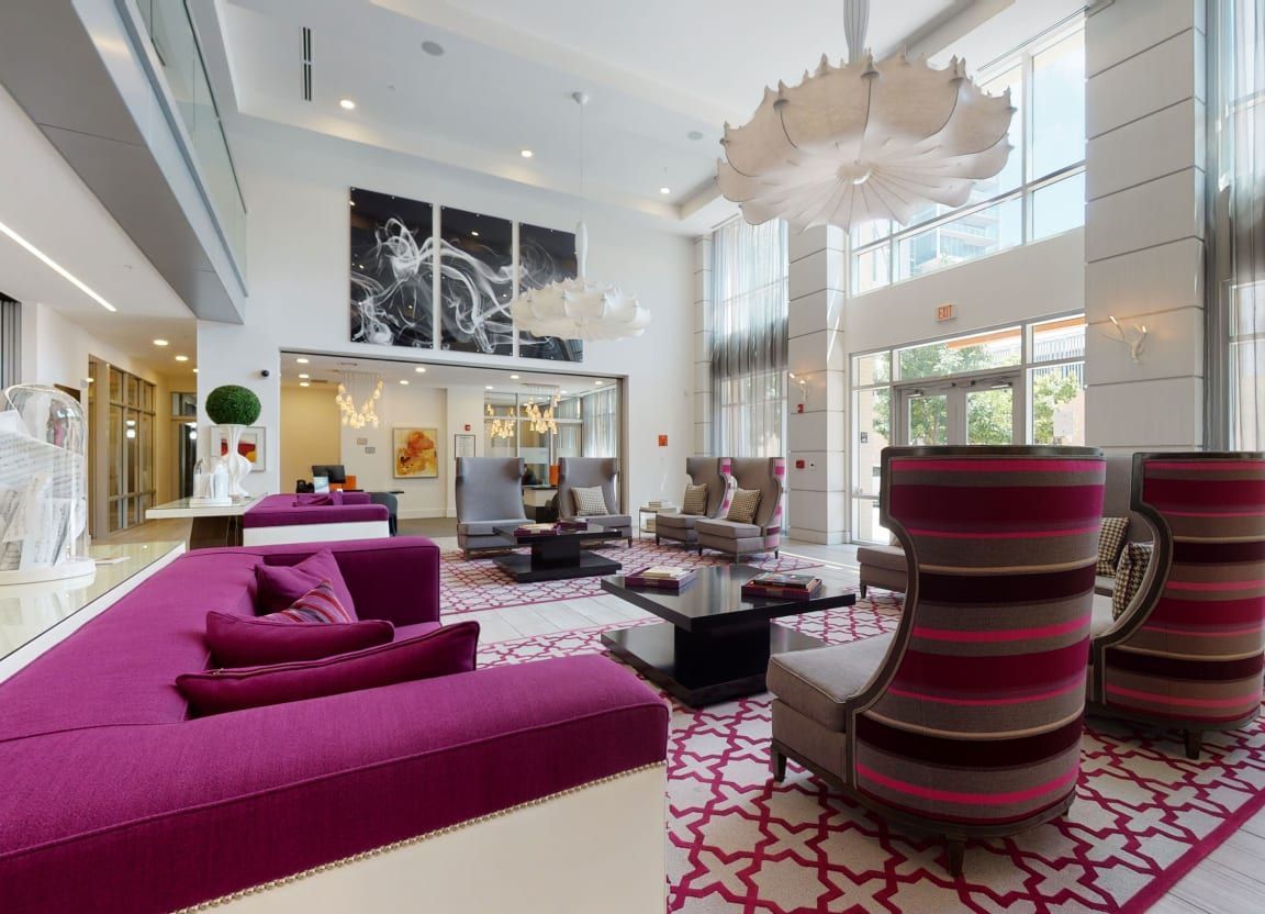 A living room with a purple couch and chairs