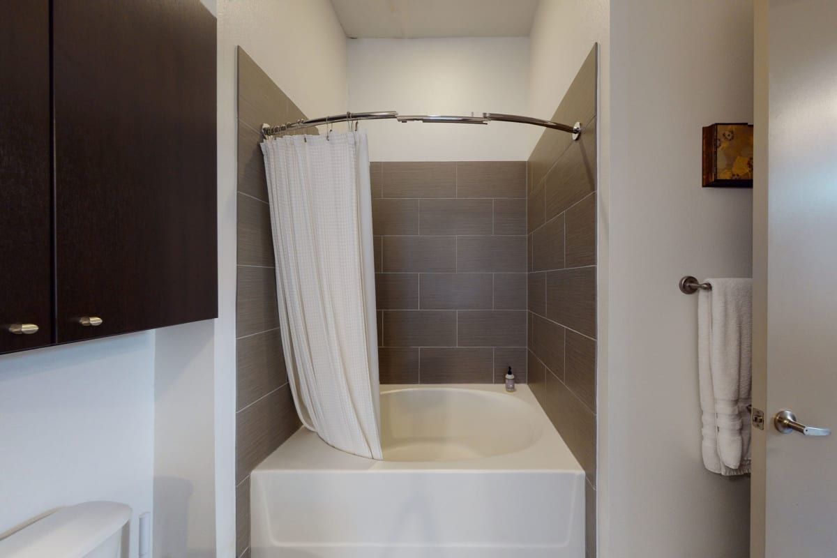 A bathroom with a bathtub and a shower curtain