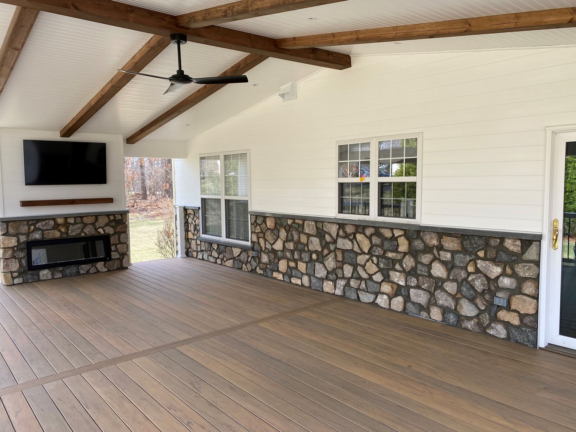 A long hallway with a glossy, light-gray floor reflecting window light. White walls and doorways.