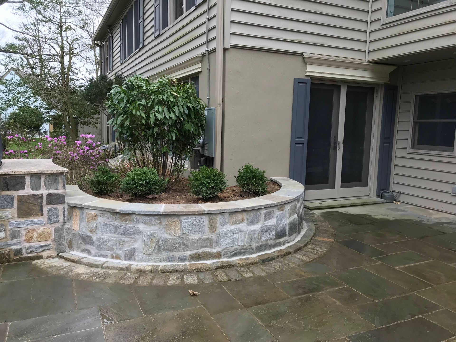 Empty garage with gray epoxy floor, white walls, and an EV charger mounted on the wall.