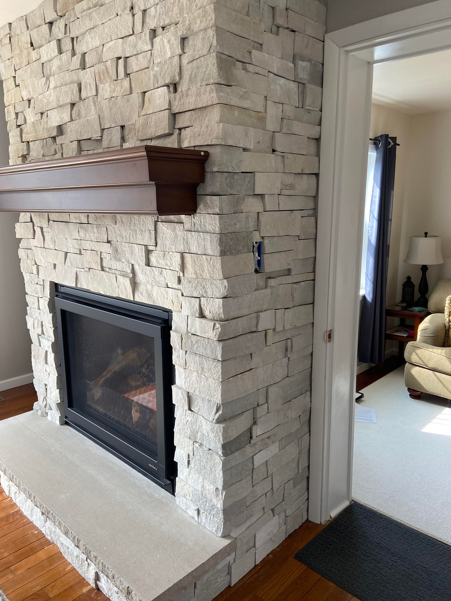 Multi-colored stacked stone wall. Colors include beige, tan, brown, and some reddish-orange.