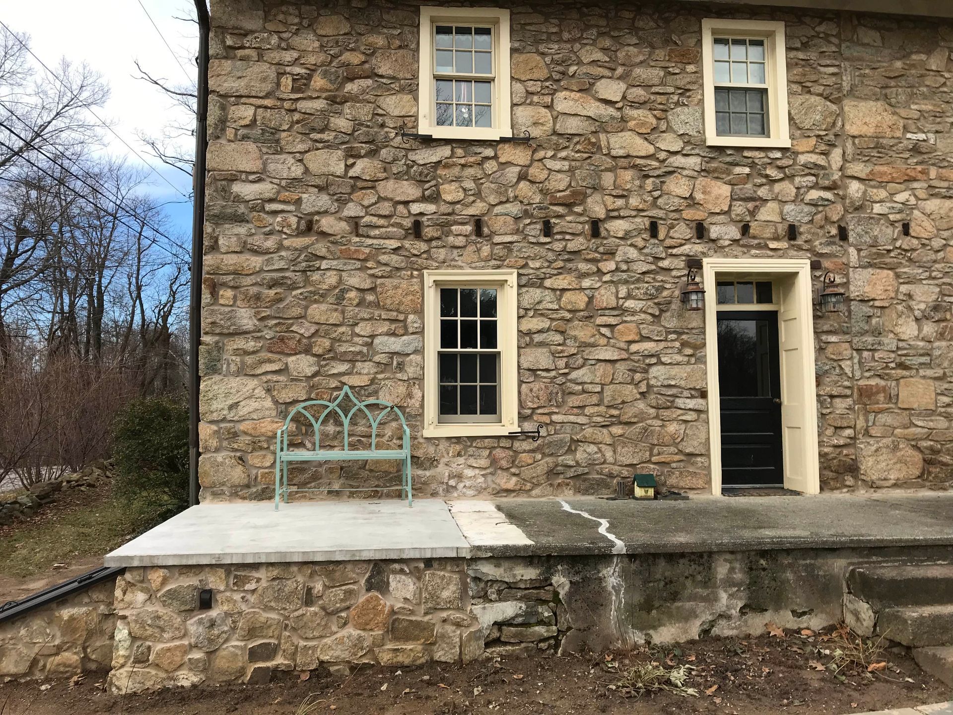Backyard patio with deck, pond, and umbrellas for shade on a sunny day.