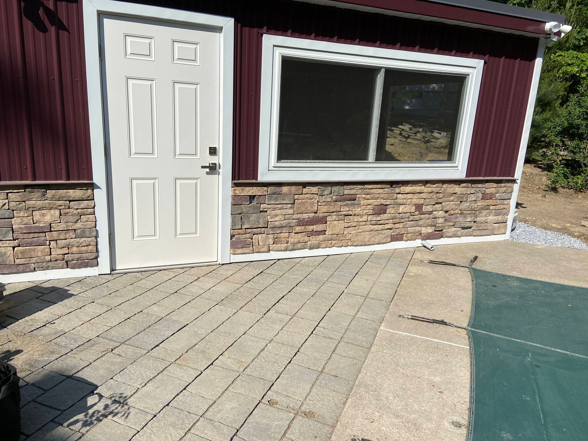 Patio with outdoor furniture on a stone patio, surrounded by landscaped gardens and greenery.