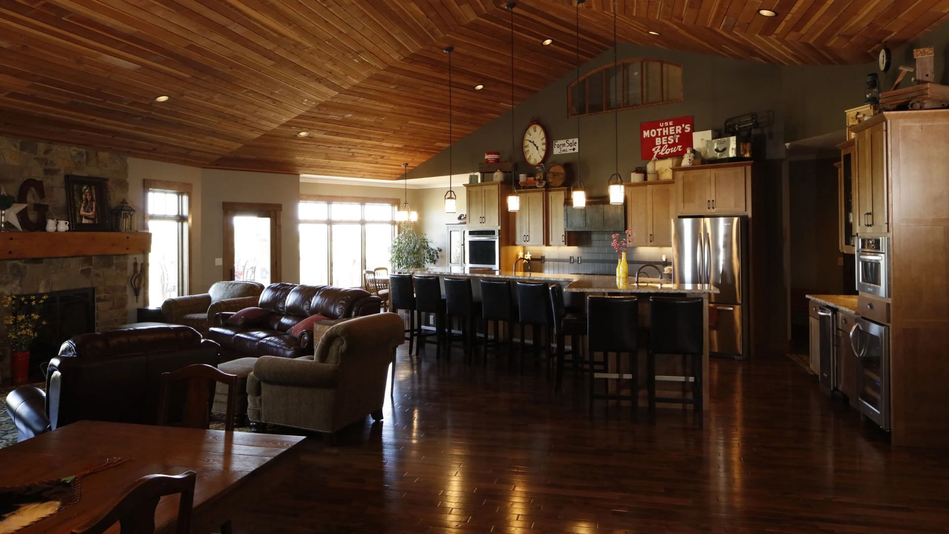 Spacious, open-concept living space with dark wood floors, kitchen island, and a fireplace.