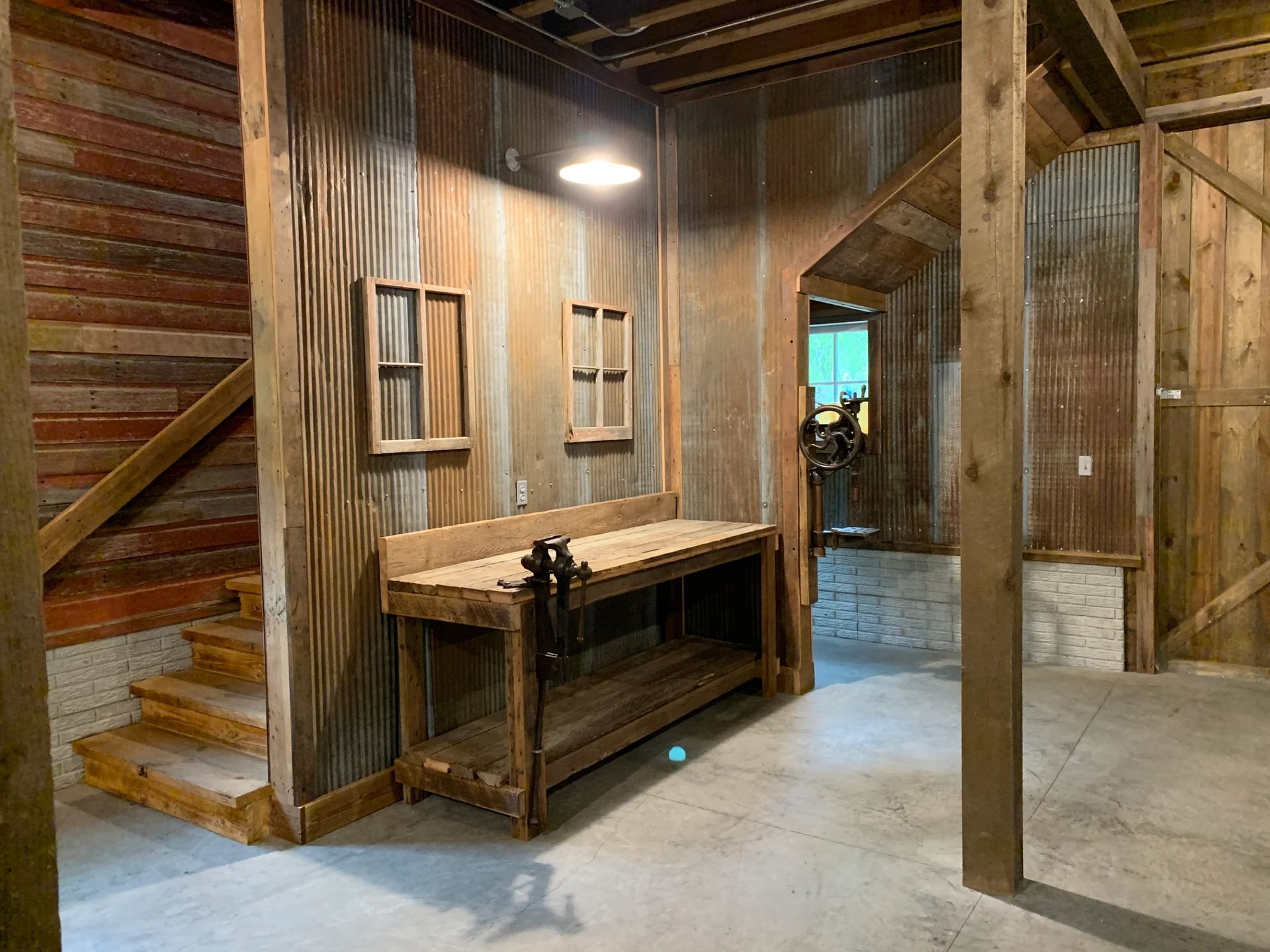 Wooden workshop with workbench, steps, and windows. Interior view with concrete floor.