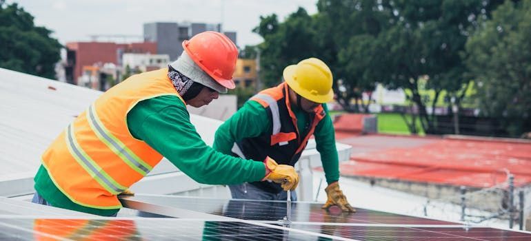 two workers installing solar panels