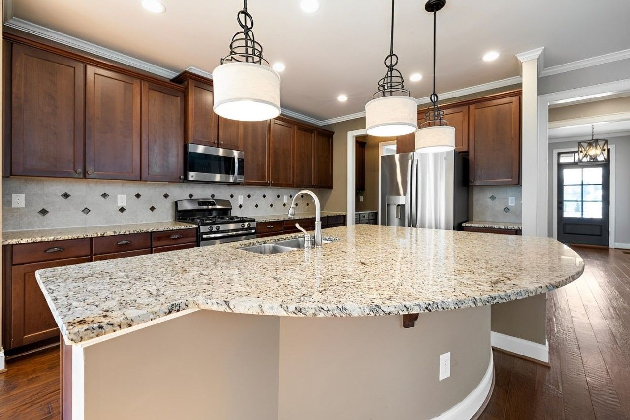 Modern kitchen with updated cabinets, granite countertops, and stainless steel appliances.